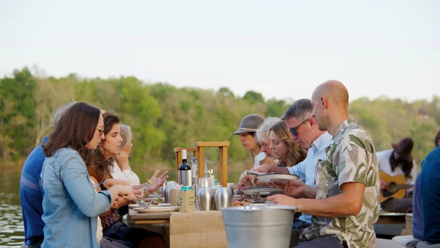 Guests serving themselves at the batteau supper, golden hour