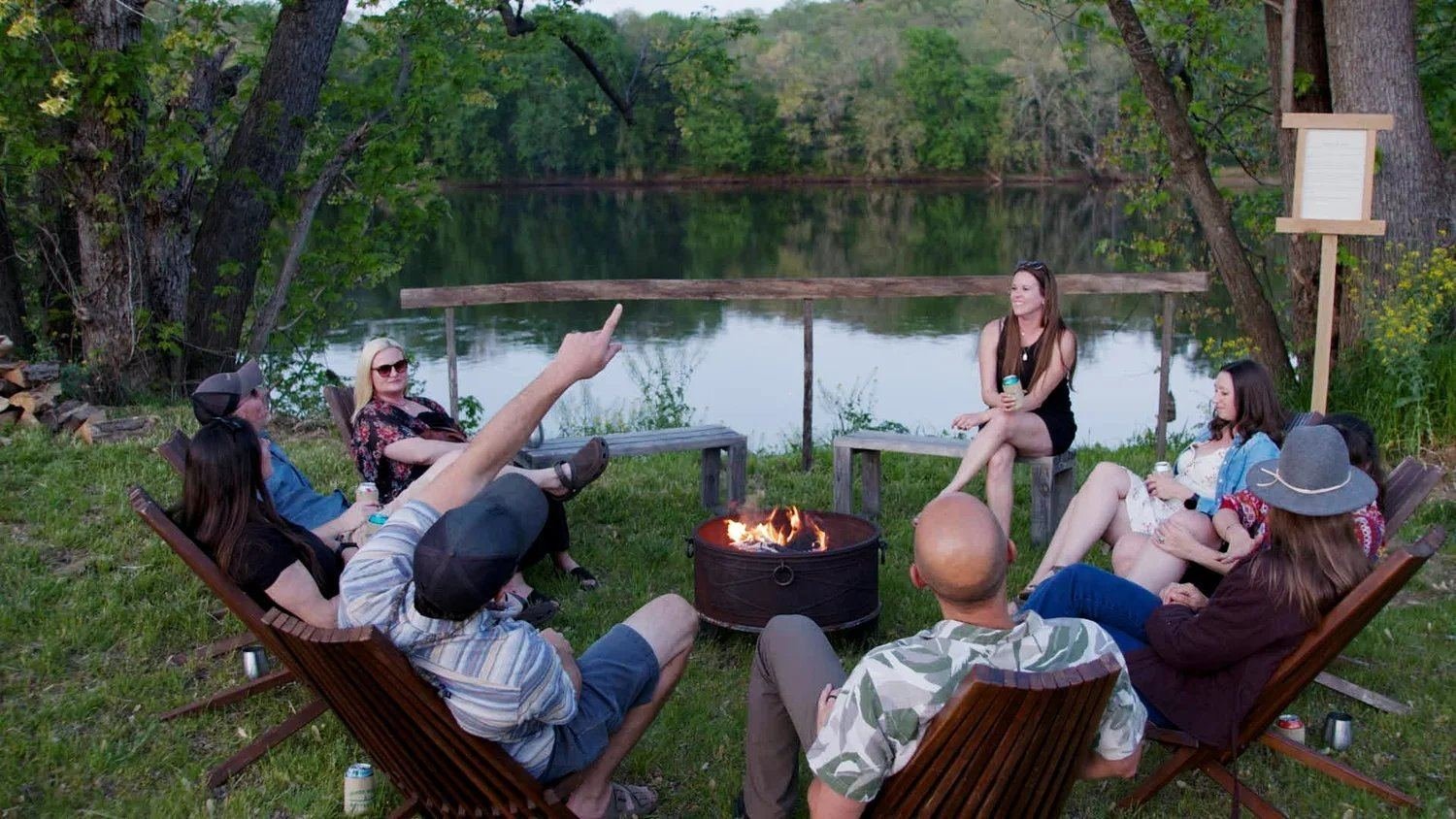 Group around the fire pit at the river's edge, golden hour