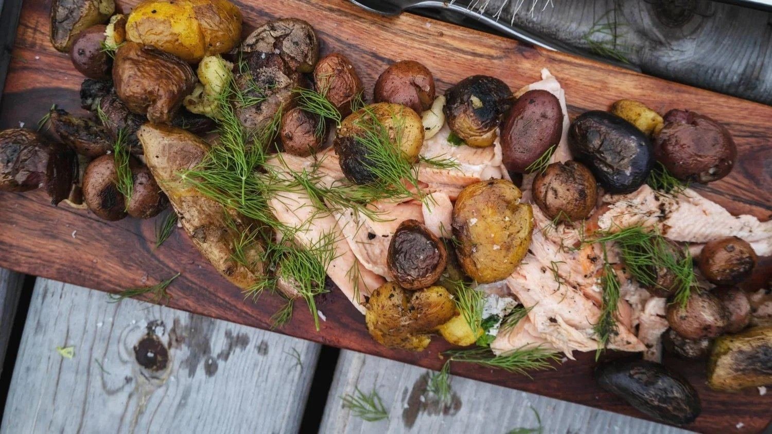 Wood-grilled fish with roasted potatoes, plated for service