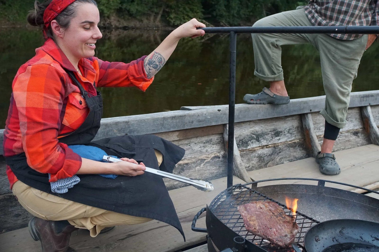 Chef Sarah grilling steaks over open fire