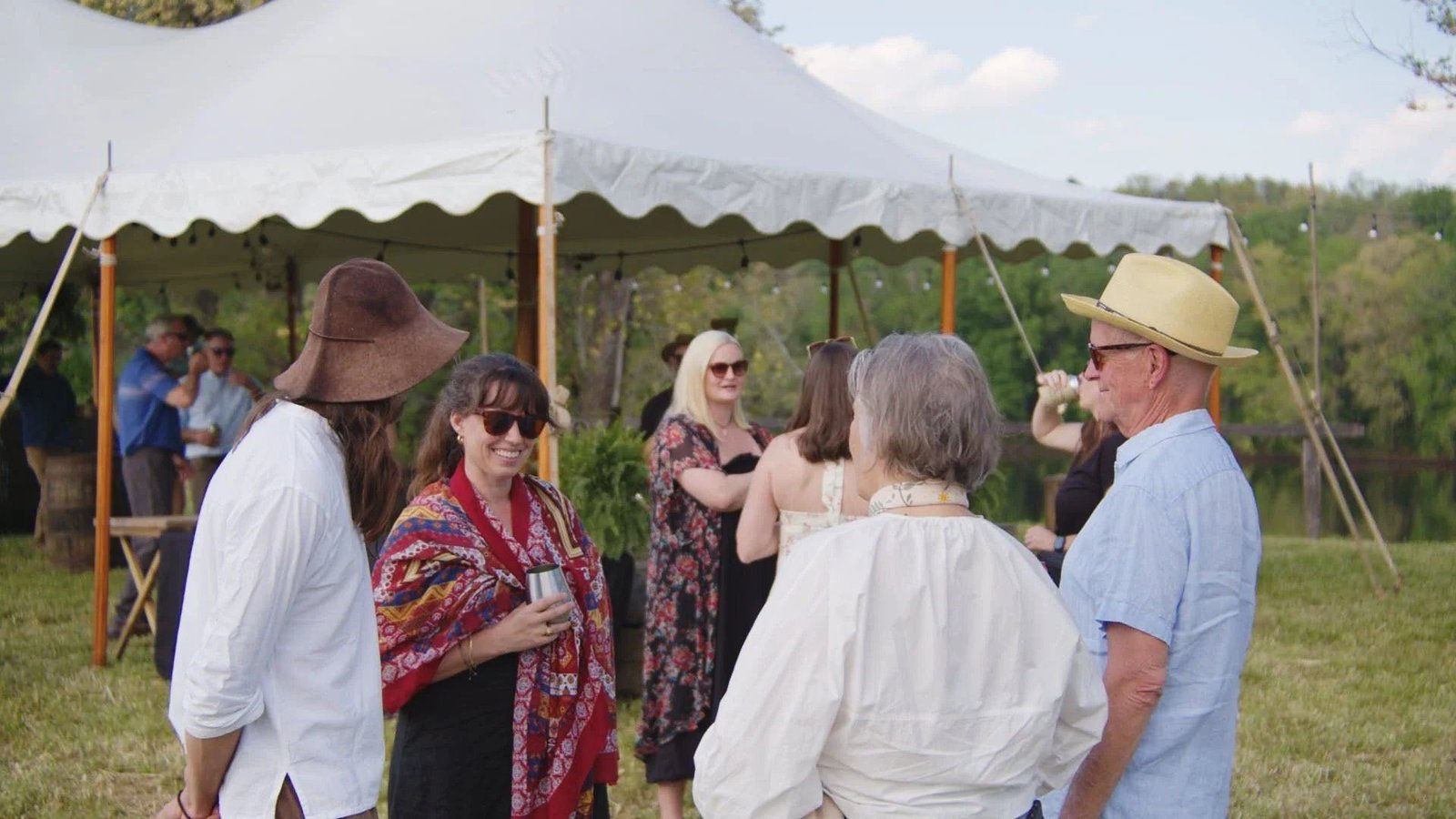 Guests at cocktail hour, sailcloth tent in afternoon