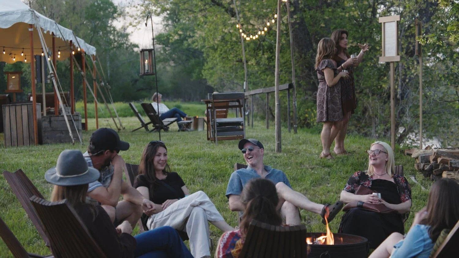 Fireside gathering with sailcloth tent at dusk