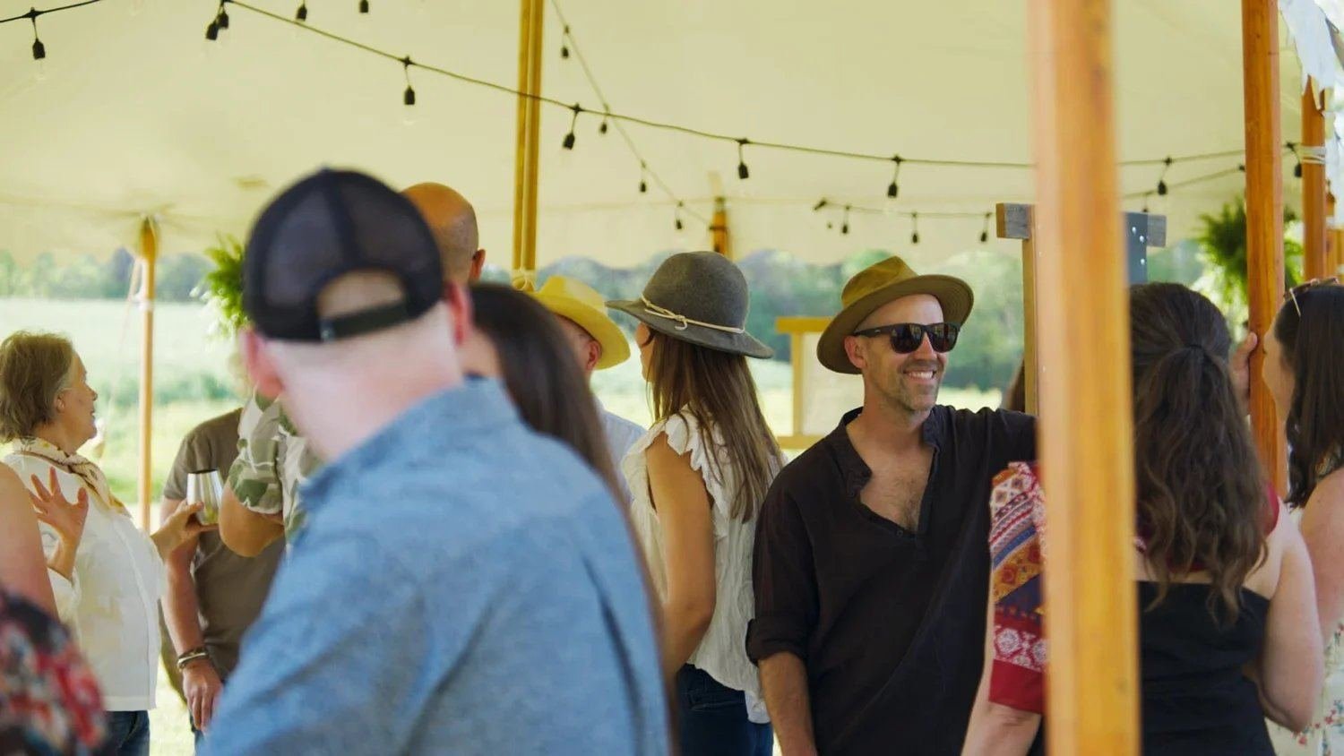 Guests mingling at the sailcloth tent during daytime