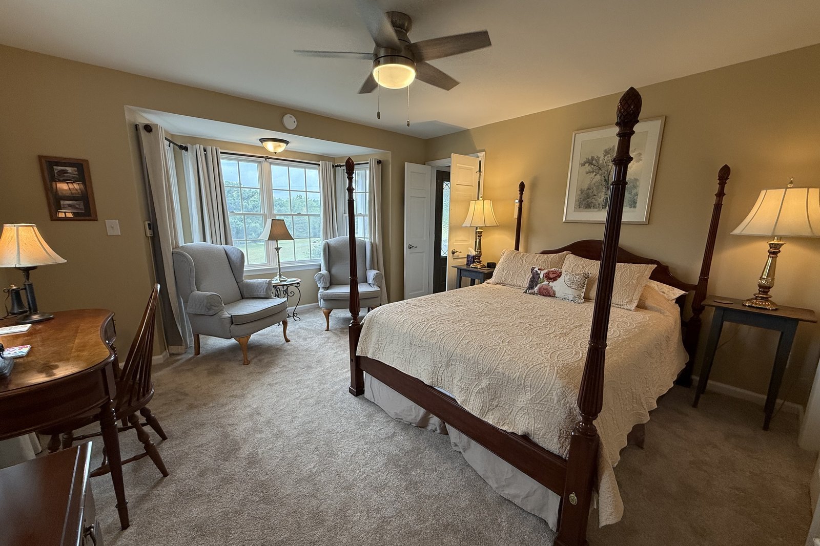 Meadowview Suite primary bedroom with four-poster bed and bay window seating